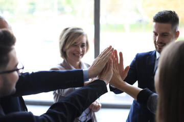 Poster - Successful business team giving each other high five standing in the office.