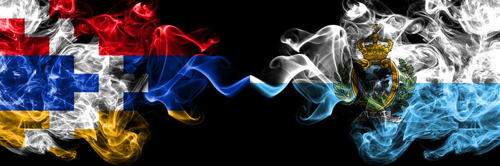 Nagorno-Karabakh, Artsakh vs San Marino, Sammarinese smoky mystic flags placed side by side. Thick colored silky abstract smoke flags