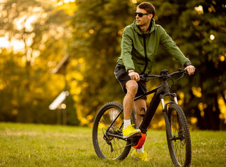 Wall Mural - Young man riding ebike in the park