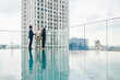 © DragonImages - Constrution company manager showing new building to investors when thay are standing on rooftop near swimming pool