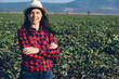 young farmer woman looks at the camera smiling in the cotton field