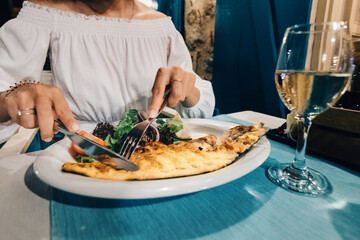 Happy woman eats grilled sea bass fish in a Mediterranean restaurant