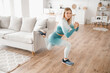 © Parilov - Slim sporty girl uses sofa to stretch her legs at home. Concept Lifestyle sports for pandemic