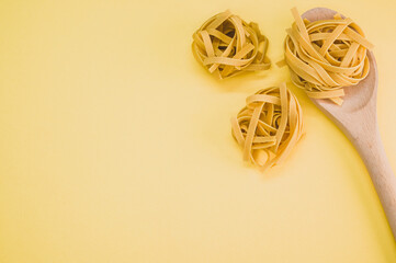 Wall Mural - Closeup shot of tagliatelle pasta and a wooden kitchen tool