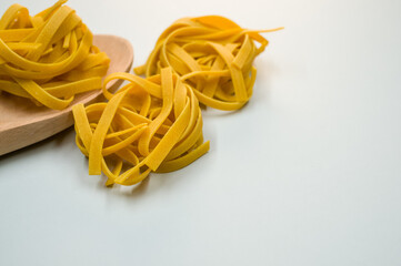 Wall Mural - Closeup shot of tagliatelle pasta and a wooden kitchen tool