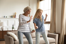 Improvised Party. Elder And Younger Women Best Friends, Aged Active Granny And Grown Grandchild Girl Spending Time Together Dancing Relaxing At Home Celebrating Housewarming, Purchasing New Apartment