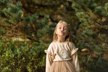 Cute stylish little girl with long blonde hair walking in autumn park. Autumn kids fashion. Happy childhood. Lifestyle portrait. Caucasian child 6 years old outdoor