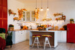 © sergiophoto - Autumn kitchen interior. Red and yellow leaves and flowers in the vase and pumpkin on light background