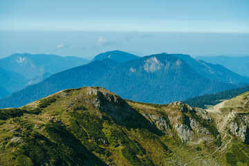 natural wallpaper with high mountains in fog and green hill