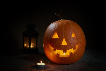 Halloween pumpkin smile and scary eyes for party night. Close up view of scary Halloween pumpkin with eyes glowing inside at black background. Selective focus