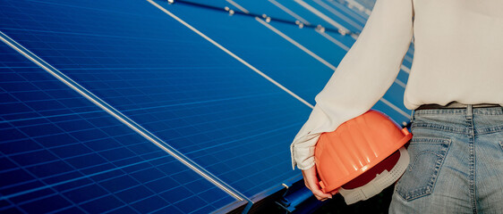 Engineer holding pink construction helmet on solar power panels background