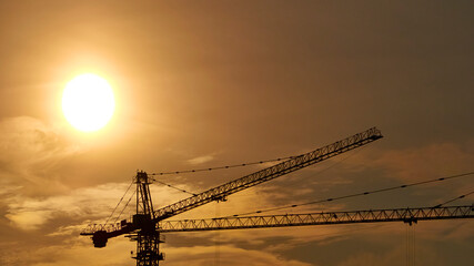 Construction crane on the background of a beautiful sky at sunset. general plan