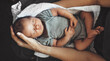 © Strelciuc - Upper view photo of a newborn baby sleeping on his parents arms