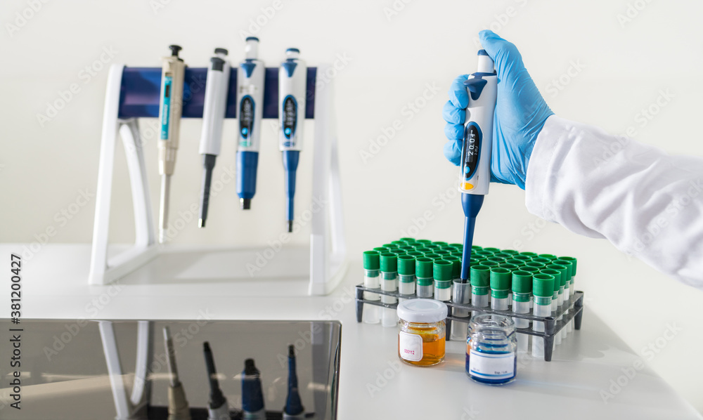 Piped Lab Pipetting lab assistant with a micropipette on white background. Hand ...