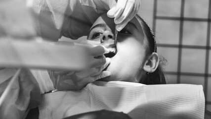 Canvas Print - Young caucasian girl caring about her teeth. Portrait of charming girl sitting in dentist chair