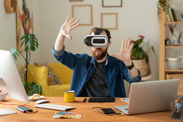 Wall Mural - Young contemporary freelancer in vr headset looking at large virtual display