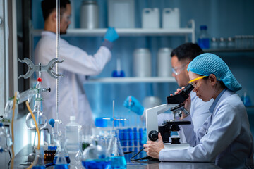 Wall Mural - young scientist looking through a microscope in a laboratory. young scientist doing some research.