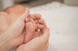 © aaalll3110 - Newborn Baby's feet. Mother and father holding newborn baby legs,legs massage