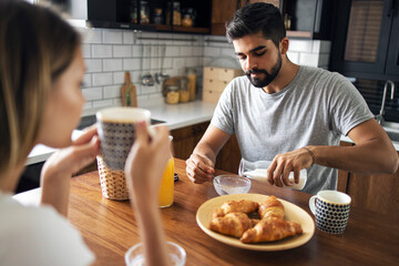 two adults having breakfast in the kitchen