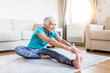 © Graphicroyalty - senior woman doing warmup workout at home. Fitness woman doing stretch exercise stretching her legs,quadriceps .Elderly woman living an active lifestyle.