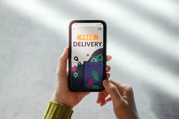 Free Delivery Promotion Concept. Digital Marketing Strategy. Closeup of Customer Woman Using Mobile Phone to Shopping Online. Free Shipment Campaign show on Screen