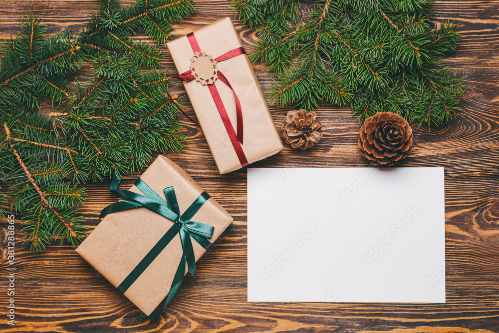 Beautiful Christmas gifts with empty card on wooden background