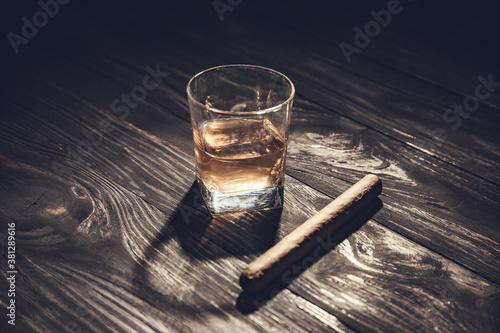 Whiskey and cigar on wooden background close up