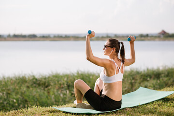 Wall Mural - Young slim fit woman doing sport exercise outdoors in the park at the sunny day