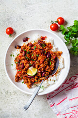 Canvas Print - Chili con carne with rice in white bowl. Beef stew with beans in tomato sauce and rice. Traditional Mexican food concept.