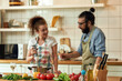 © Svitlana - Young couple preparing a meal together in the kitchen. Italian man, chef cook looking at his girlfriend, holding glass of white wine. Cooking at home, Italian cuisine