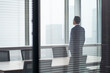 © imtmphoto - asian corporate executive standing in front of window thinking
