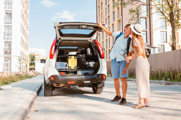 Wall Mural - couple gathering for road trip. putting bags to car trunk