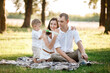 © Andriy Medvediuk - father, mother and son in the park together on a sunny summer day. happy young family having fun outdoor