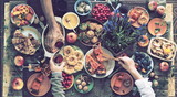 Fototapeta Uliczki - Country style. Thanksgiving table. A lot of food. The guests is hands hold wine over the set table. View from above.Art processing vintage