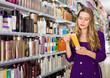 © JackF - Focused interested glad positive girl shopping in cosmetics store looking for hair care treatments