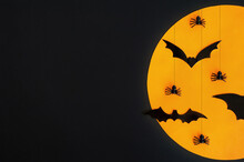 Halloween. Composition. Black Bats And Spiders Against The Orange Moon And Black Background. Copy Space.