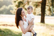© Andriy Medvediuk - Happy mother with the son in the park on summer park. mom and baby girl having fun outdoors. family concept. selective focus
