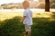 © Andriy Medvediuk - Happy adorable baby boy walks on the grass in the park on summer day. Child in trendy and cute clothes