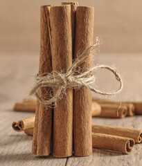 Sticker - Vertical closeup shot of a bundle of cinnamon sticks on a blurred background