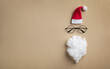 © juliasudnitskaya - Creative Christmas greeting card, invitation or flyer. Santa hat, beard and glasses on golden background top view. Flat lay.
