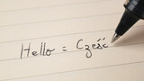 Fototapeta  - Beginner Polish language learner writing Hello word Czesc for homework on a notebook