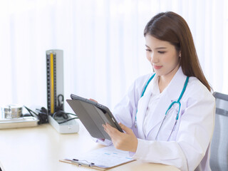 Asian female doctor working report of her patient on tablet