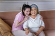 © lukyeee_nuttawut - Asian young woman take care and  support with hug, that make feel good and smile older mother in living room. family concept
