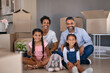 © Rido - Happy multiethnic family sitting on floor in new home