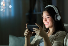 Happy Woman Watching Videos On Smart Phone In The Night