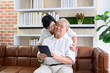 © tonefotografia - A happy senior Asian couple is using tablet and talking with family on webcam at home, retirement concept.