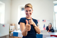 Portrait Of Happy Woman Voter With Tumb Up In Polling Place, Usa Elections Concept.