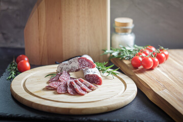 Assorted sliced italian salami on wooden plate