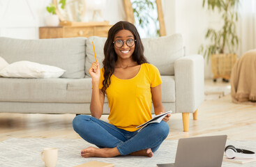 Wall Mural - Online education. Pretty black female student sitting in front of laptop computer and participating in webinar from home