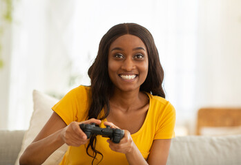 Poster - Weekend entertainments. Happy black lady with joystick playing online computer games indoors